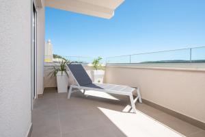 a chair sitting on the balcony of a building at Apartman Maestro in Trogir