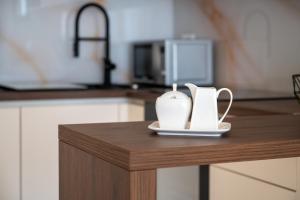 two white vases sitting on a table in a kitchen at Apartman Maestro in Trogir