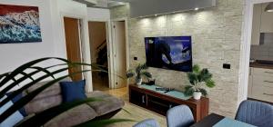 a living room with a tv on a stone wall at Los Cristianos Penthouse in Arona