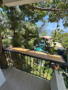 a balcony with a wooden railing and a view of a house at Casa don valentinos in Santa Catarina Palopó