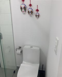 a bathroom with a toilet with masks on the wall at B&B KELLY Ecuador in Quito