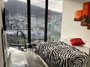 a zebra print bed in a room with a large window at B&B KELLY Ecuador in Quito