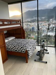 a bedroom with a bed and exercise equipment in front of a window at B&B KELLY Ecuador in Quito