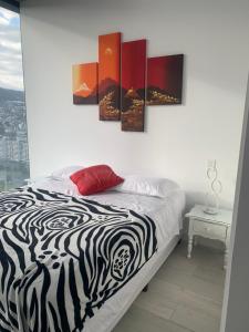 a bedroom with a bed with a zebra print painting on the wall at B&B KELLY Ecuador in Quito +11 photos