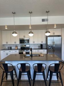 a kitchen with a large kitchen island with four chairs at Sonoro Sands in Hurricane