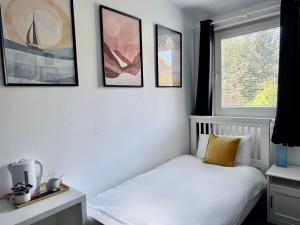 a bedroom with a bed and framed pictures on the wall at Roost Hill - Free Parking Zone in Edinburgh
