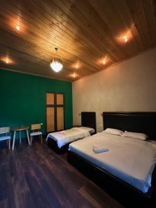 a room with two beds and a green wall at Local Hotel in Tbilisi City