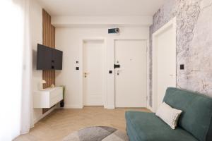 a living room with a green couch and a tv at Platea Magna Lux Apartment in Zadar