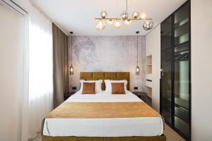 a bedroom with a large bed and a chandelier at Platea Magna Lux Apartment in Zadar
