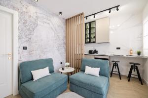 a kitchen with two blue chairs and a table at Platea Magna Lux Apartment in Zadar