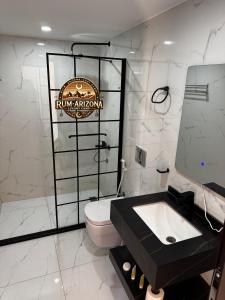 a white bathroom with a toilet and a sink at RUM ARIZONA lUXURY CAMP in Wadi Rum +107 photos