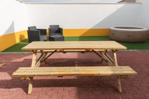 a wooden picnic table and bench in a room at The Centenaria in Leiria