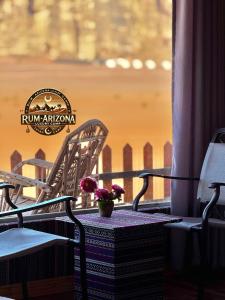 Un jarrón de flores sobre una mesa en un balcón. en RUM ARIZONA lUXURY CAMP, en Wadi Rum