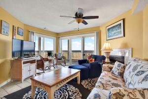 a living room with a couch and a tv at Ocean front condo Sandcastles beach club in Tybee Island