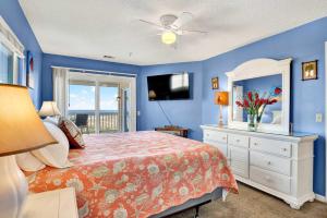 a bedroom with a bed and a dresser and a mirror at Ocean front condo Sandcastles beach club in Tybee Island
