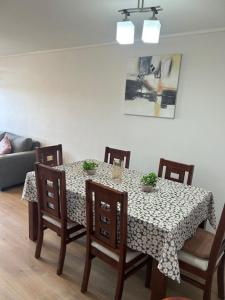 a dining room table and chairs with a table and a couch at Departamento Talcahuano Factura Empresas in Talcahuano