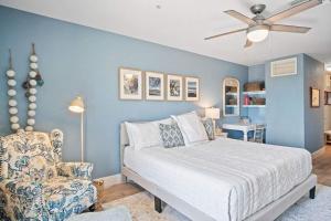 a blue bedroom with a bed and a chair at Grand Caribbean 2009 in Port Aransas