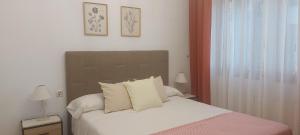 sypialnia z łóżkiem z białymi prześcieradłami i poduszkami w obiekcie Apartamento Sobrevilla SDR IV Sardinero w mieście Santander