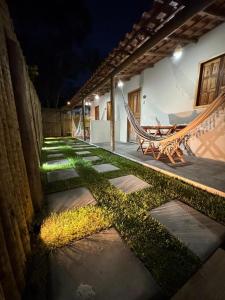 un jardín con una hamaca y un patio por la noche en Vila Kairós, en Caraíva