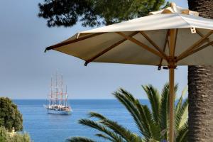 a white umbrella and a boat in the water at Hotel Continental in Santa Margherita Ligure