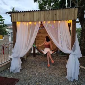 a woman sitting on a swing in a gazebo at 06 Residencial Lazzaris a poucos metros do Beto Carrero in Penha