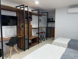 a bedroom with a bunk bed and a desk at Kapital Suites in Pereira