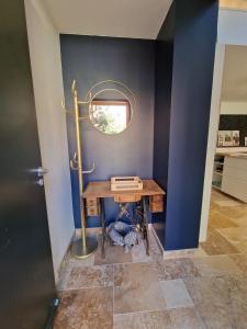 a room with a table with a mirror on a wall at Maison neuve clim terrasse TV wifi fibré parking in Oullins