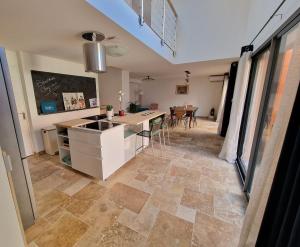 a kitchen with a counter and a table in a room at Maison neuve clim terrasse TV wifi fibré parking in Oullins