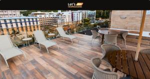 un balcone con tavoli e sedie in un edificio di Let's AX Fortune a Tambaú