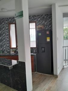 a kitchen with a black refrigerator in a room at Apartaestudio 405 in Acacías