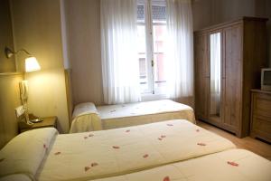 Habitación de hotel con 2 camas y ventana en Hostal Orejas en León