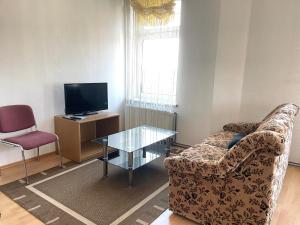 un soggiorno con un divano, un tavolo e una TV di New Living Home a Boizenburg