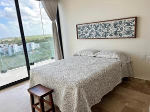 una camera da letto con un letto e una grande finestra di DSoleil a Cozumel Altre 19 foto