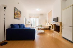 a living room with a blue couch and a fireplace at Estúdio Kubata Hill in Parede