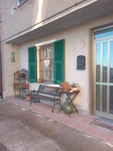 a bench sitting outside of a window with green shutters at La Corte del Gavi in Bosio