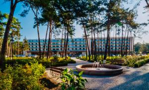 a building with a fountain in the middle of a park at Apartament Zdrojowy Wieniec Zdrój in Włocławek