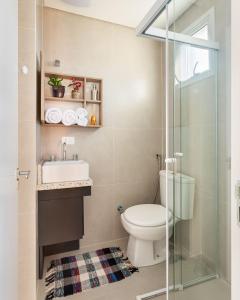 Un baño con inodoro, lavabo y ducha. en Studio com churrasq 650m da Torre Panorâmica RME047, en Curitiba