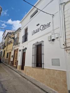 a white building with a sign on it on a street at La Posada del Olivar in Baena +32 photos