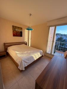 une chambre avec un lit et une grande fenêtre dans l'établissement Superbe Appartement T3 vue mer en centre ville à 5 minutes à pied de la plage, à Cavalaire-sur-Mer