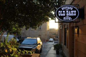 a sign for a old bank with a car parked on a street at Old Baku Boutique Hotel in Baku