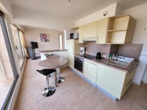 une cuisine avec un comptoir et une table à l'intérieur dans l'établissement Superbe Appartement T3 vue mer en centre ville à 5 minutes à pied de la plage, à Cavalaire-sur-Mer 6 autres photos