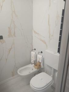 biała łazienka z toaletą i umywalką w obiekcie Hotel Baiardo w mieście Romagnano Sesia