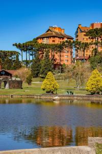 a building on top of a hill next to a lake at Rosa Edificio Jardim dos Lagos in Canela