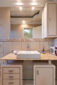 a kitchen counter with a sink and a mirror at Rosa Edificio Jardim dos Lagos in Canela