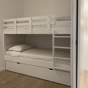 a bunk bed with white bunk beds in a room at LuxuryApartmentBaiaBlanca Pool & Free Parking in Lido di Jesolo +8 photos