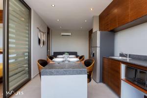 a kitchen with a table with chairs and a refrigerator at 1 bedroom with park view in condominium with gym sauna and steam room in Tulum