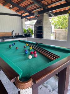 a pool table with balls on top of it at Casa 02 Quartos à 900m Praia e 3km do Beto Carrero - Estacionamento - Area de LAZER com Churrasqueira e Sinuca - Wi-Fi e Cozinha Completa in Penha