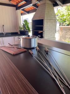 a kitchen counter with a pot and utensils on it at Casa 02 Quartos à 900m Praia e 3km do Beto Carrero - Estacionamento - Area de LAZER com Churrasqueira e Sinuca - Wi-Fi e Cozinha Completa in Penha