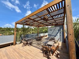 圣路易斯Your Home - Studios Boutique Hotel的木制凉亭,甲板上配有桌椅