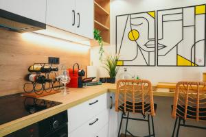 a kitchen with white cabinets and a counter with two stools at Liebe 16 luxurious stay in Volos +15 photos